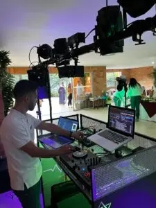 DJ en Medellín de Loop Eventos realizando mezclas en vivo con equipo de sonido profesional y cabina iluminada.