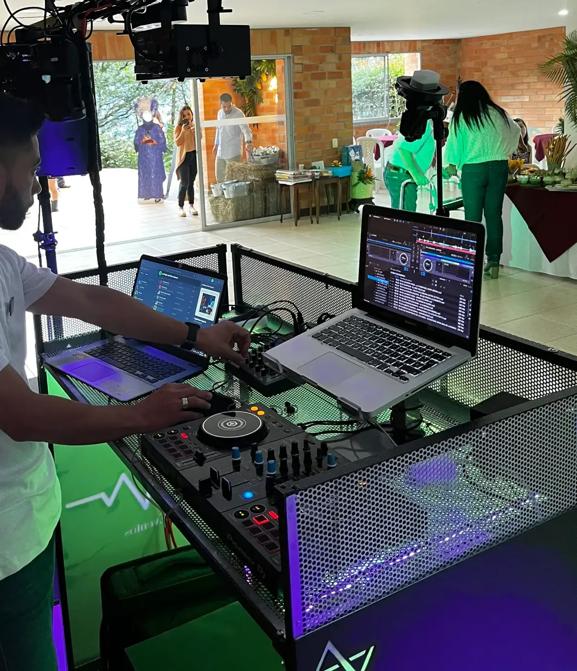 DJ en Medellín de Loop Eventos realizando mezclas en vivo con equipo de sonido profesional y cabina iluminada.